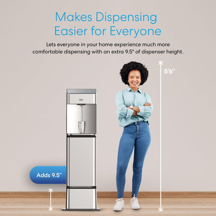 A smiling woman stands beside the Brio Water Cooler Base – 730 Series, which adds 9.5 inches, making the dispenser 56 inches tall and ensuring easier, more comfortable access for all users.