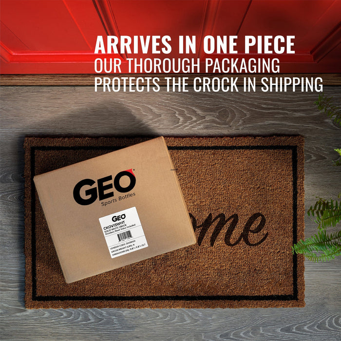 A cardboard box labeled GEO Porcelain Ceramic Crock Water Dispenser – Black sits on a doormat in front of a red door. Text above reads: Arrives in one piece. Our sturdy packaging protects your dispenser during shipping.