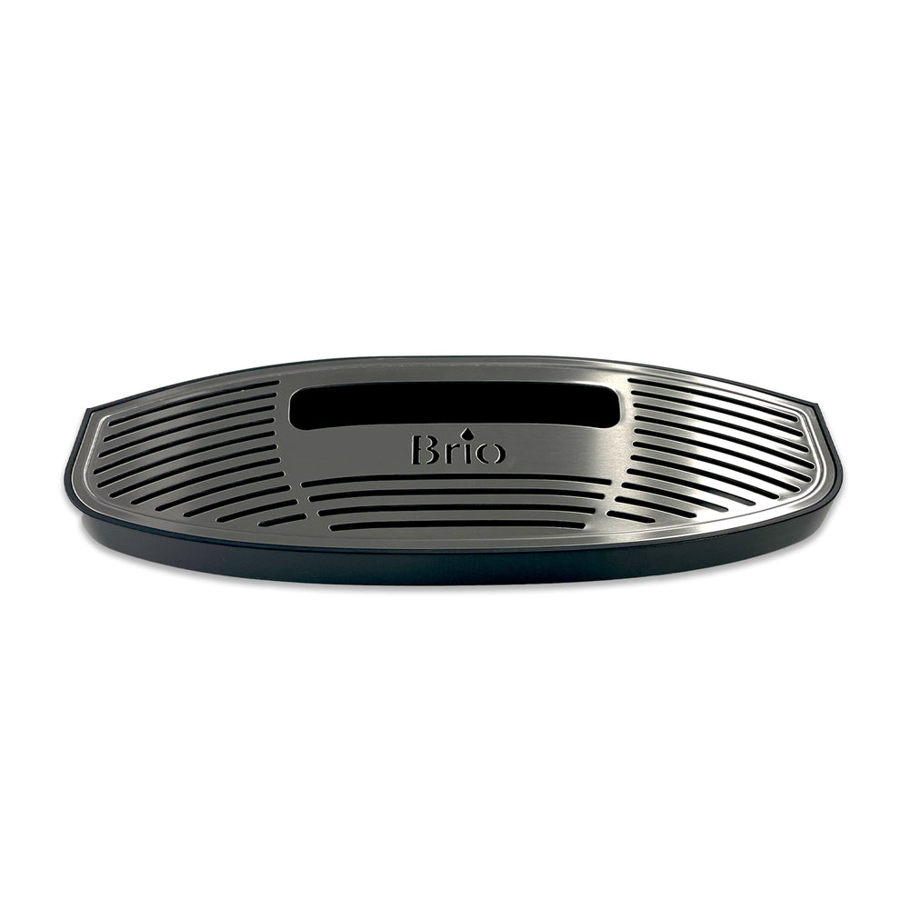 A black, oval plastic drip tray for Brio 320, 420 & 520 Series Icemaker Coolers features a grated surface, rectangular center cutout, and "Brio" embossed near the middle.