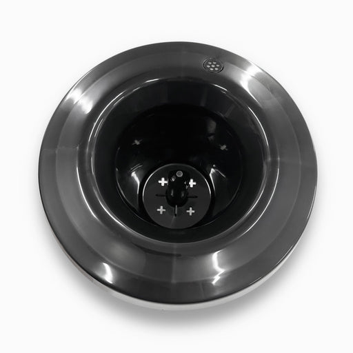 A top-down view of a shiny stainless steel Non-Spill Top 420, 520 Coolers base with a dark central blade and visible plus and minus symbols, set against a white background.