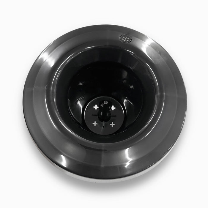 A top-down view of a shiny stainless steel Non-Spill Top 420, 520 Coolers base with a dark central blade and visible plus and minus symbols, set against a white background.