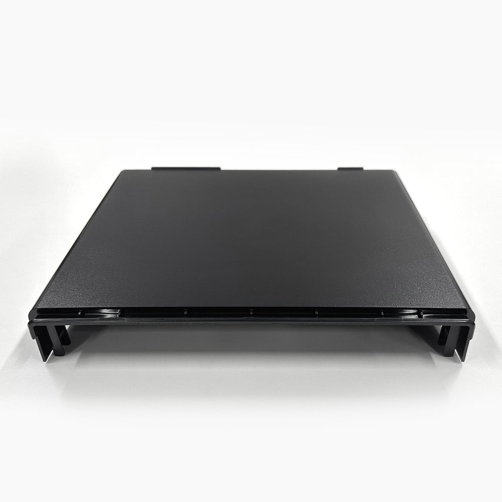 A black, rectangular Top Lid 520 Series Cooler stand is shown on a white surface, viewed from the front at a slight angle. It features raised edges and four short legs.