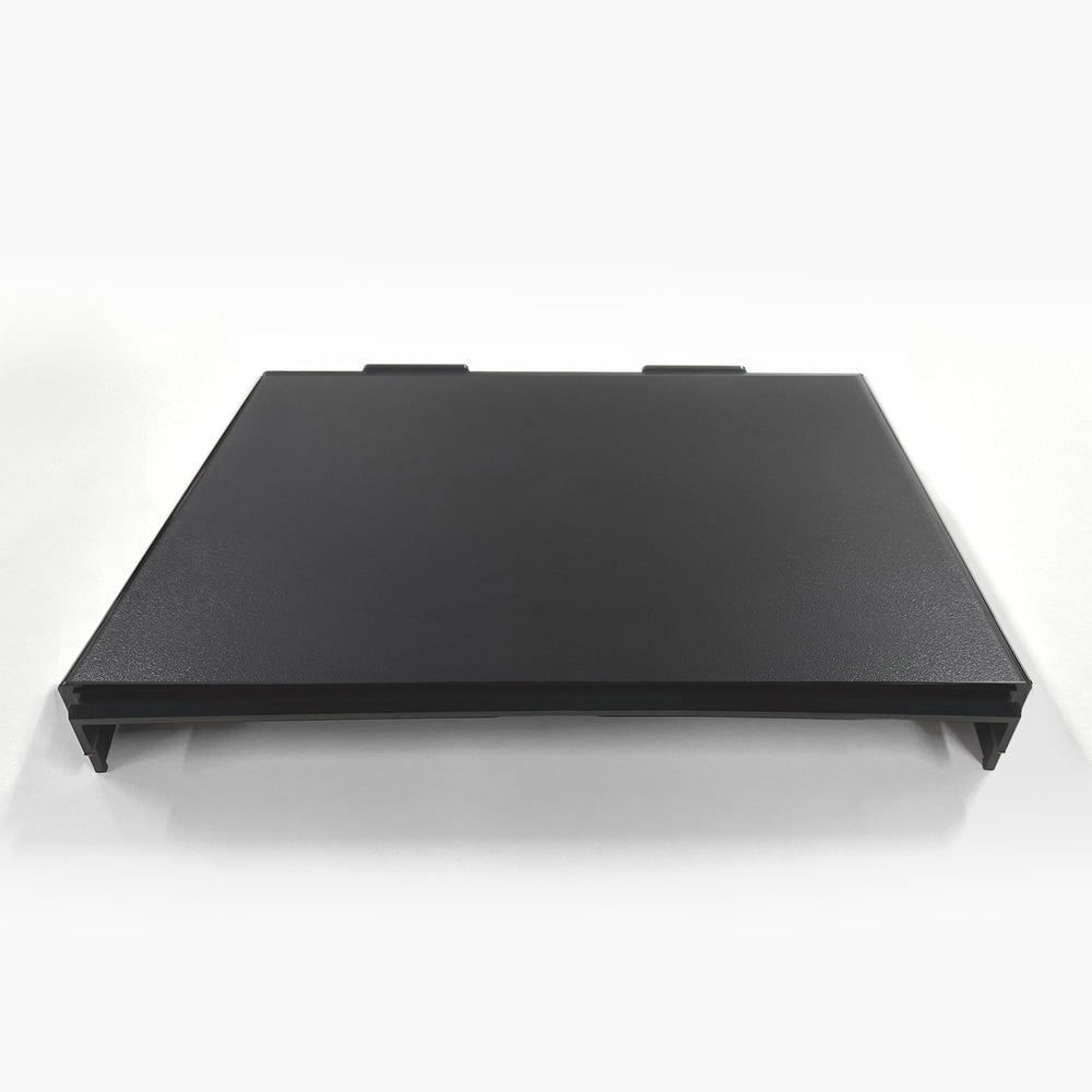 A black, rectangular Top Cover for Brio 320, 420 & 520 Series Icemaker Coolers with two tabs on the back edge, shown flat on a white surface against a plain white background.