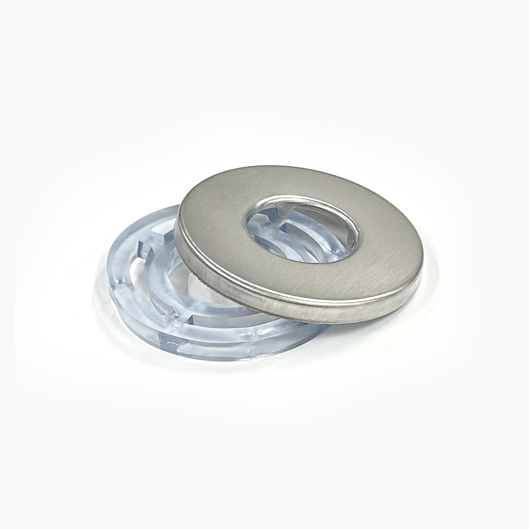A metal Faucet Base for Prism Tankless Unit, featuring a central hole, sits on a matching clear plastic ring—both displayed on a white background to highlight their compatibility.
