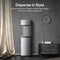 Stainless steel water dispenser against a gray wall with decorative elements.